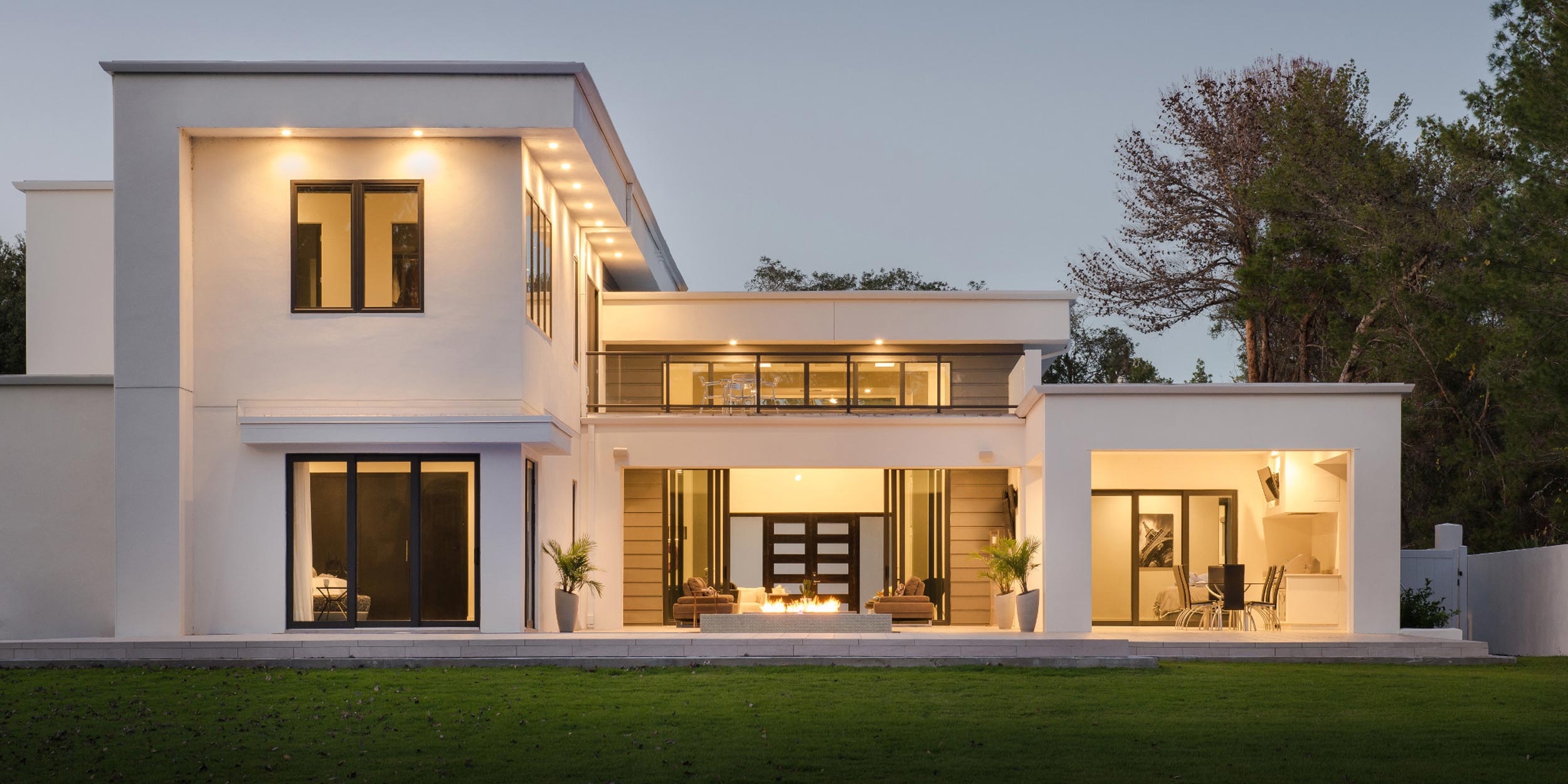 white modern home photographed at dusk