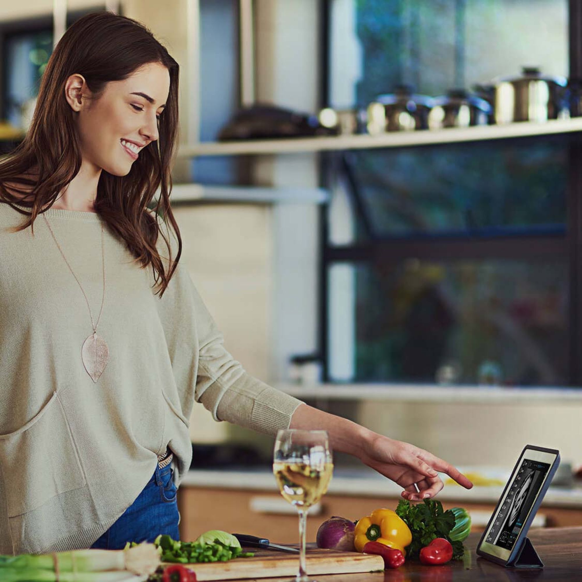 woman in a kitchen interacting with a touch panel