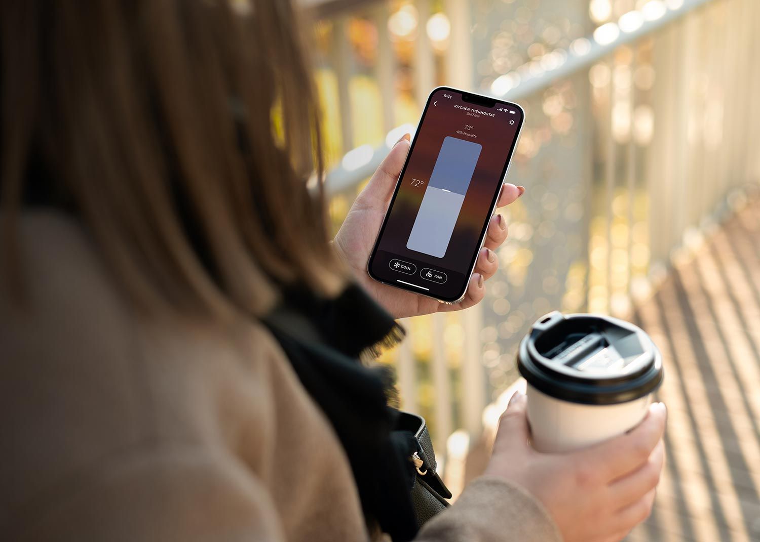 Woman on her side holding a coffee and an iPhone with a Josh.ai App screenshot